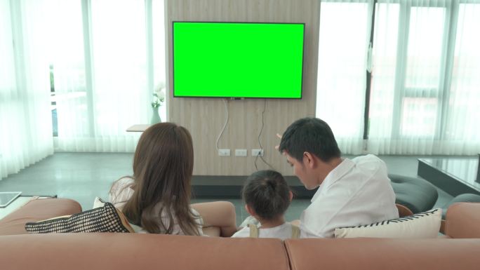快乐家庭在家里的客厅里坐着看电视