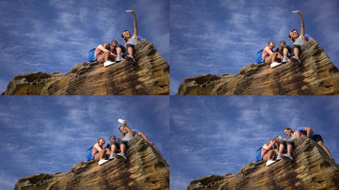 一群朋友坐在悬崖边，微笑着自拍