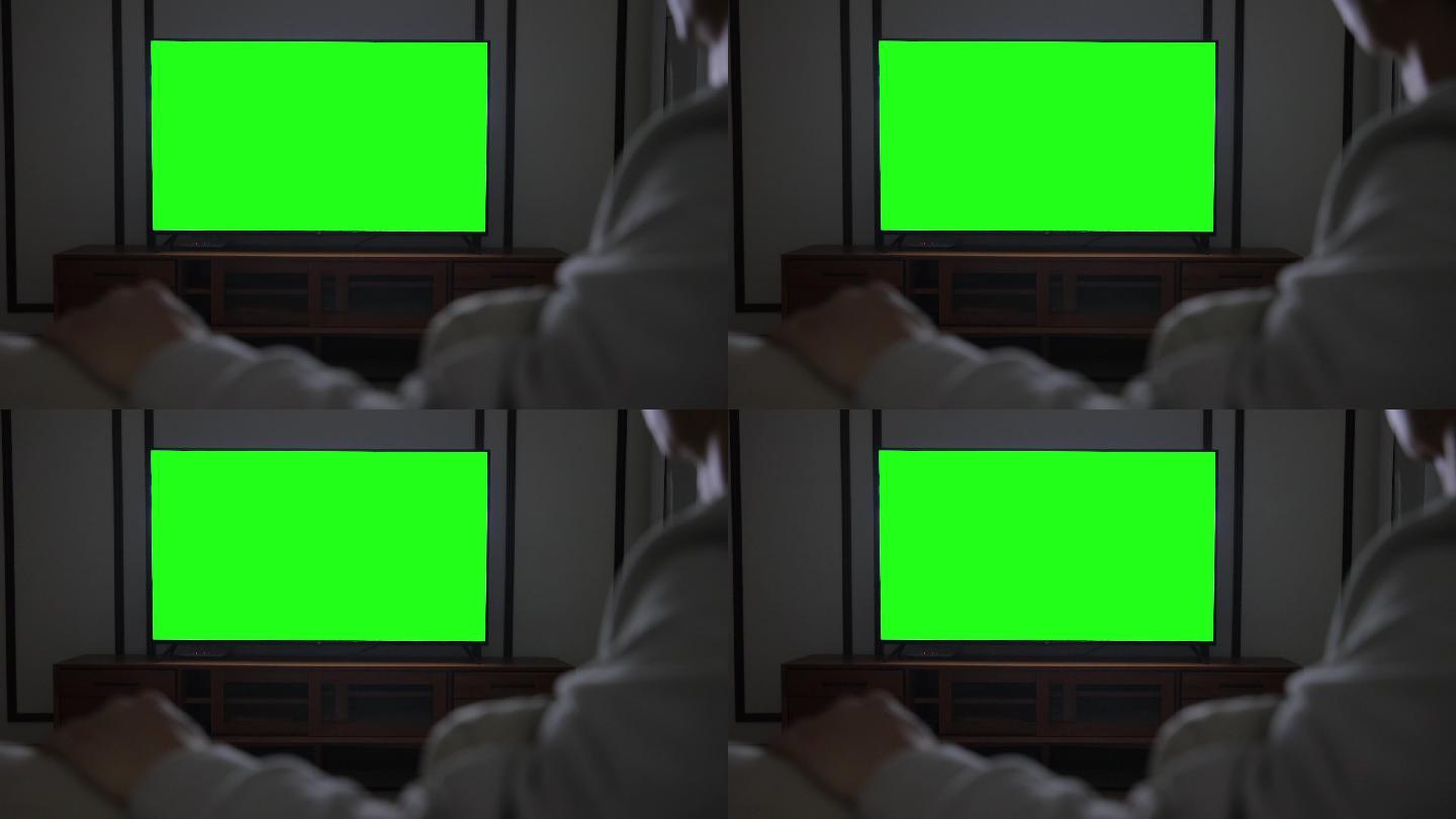 男子用绿色屏幕看电视