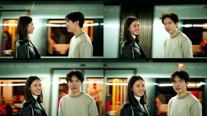 一对年轻夫妇在地铁站看着摄像机微笑着。