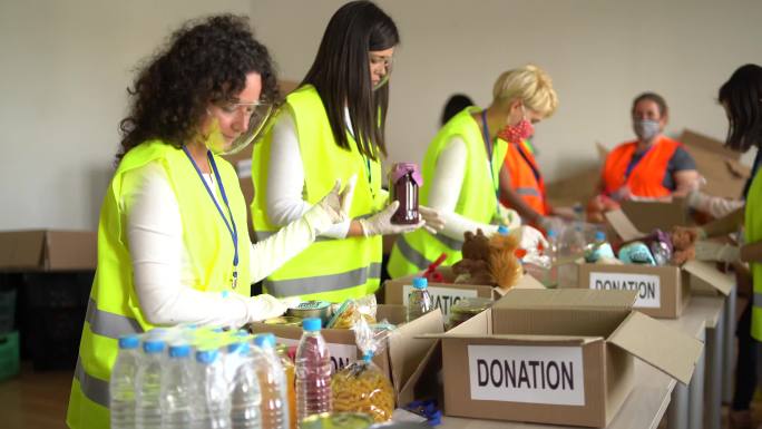 大流行期间，志愿者在仓库里收集食物捐赠