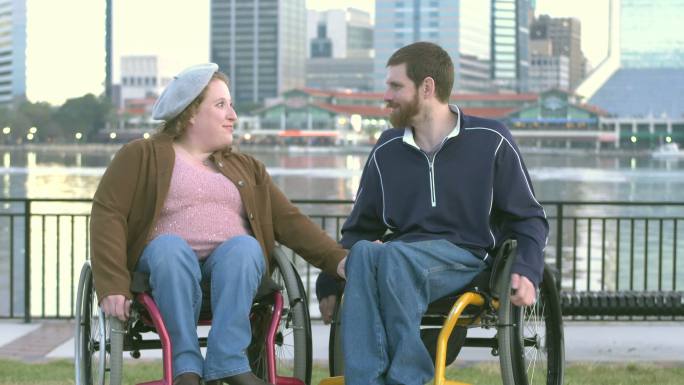 坐轮椅的夫妇在城市滨水区交谈