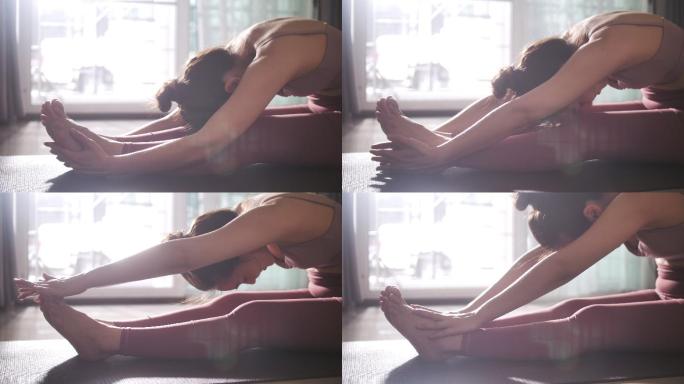 年轻女子早晨在家练习瑜伽