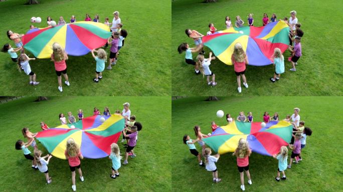 用降落伞玩球类游戏的孩子们
