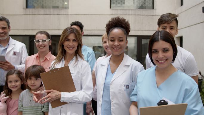 一群病人和医护人员站在一起对着镜头微笑