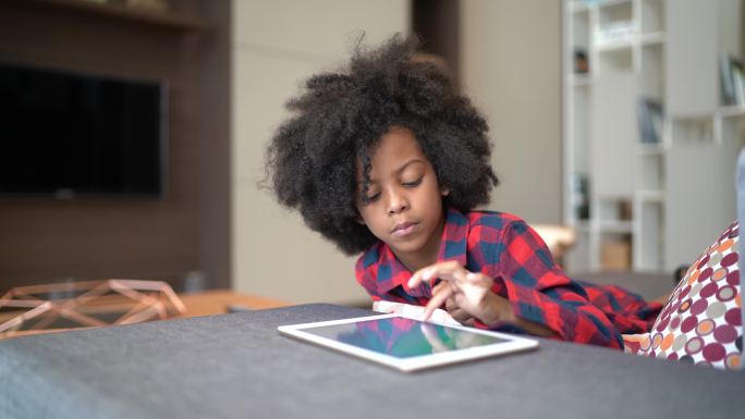 一个孩子在家玩数字平板电脑