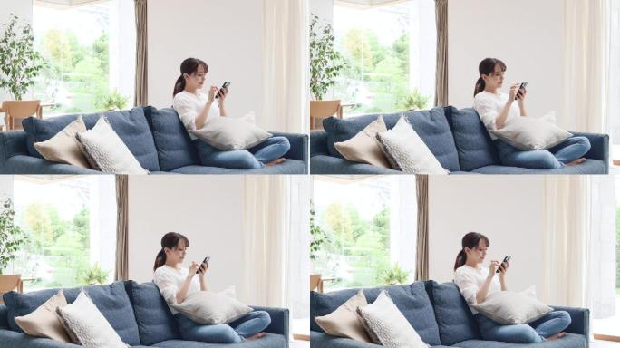 女性在沙发上使用智能手机