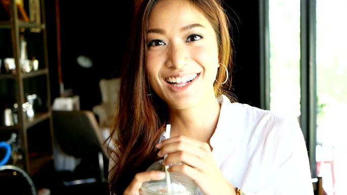 亚洲女人喝冰咖啡吸管过曝素材东南亚