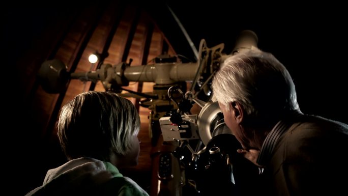 祖父和孙子在天文台观察星空