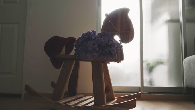 客厅里的马凳上有紫罗兰花和红帽子