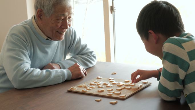 爷爷和孙子在家玩日本象棋