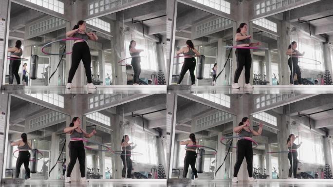 超重女子在健身房打呼拉圈。