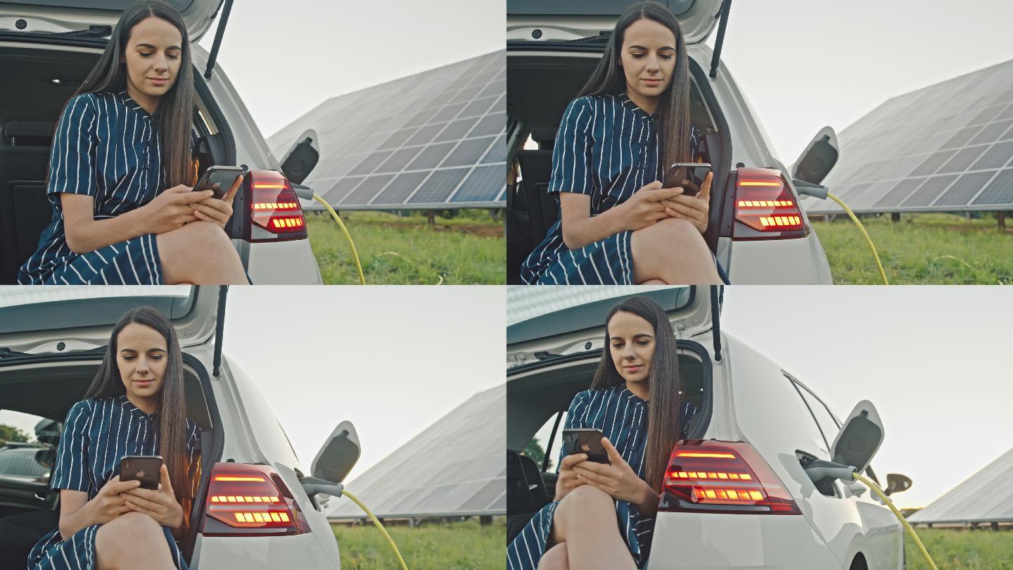一位女士在汽车后备箱里使用手机