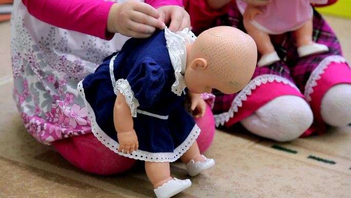 打扮娃娃的女孩小女孩玩偶穿衣服