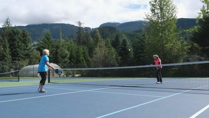 两名女子在网球场上打球
