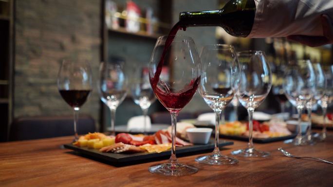 将葡萄酒倒进玻璃杯在酒窖里摆桌子品酒