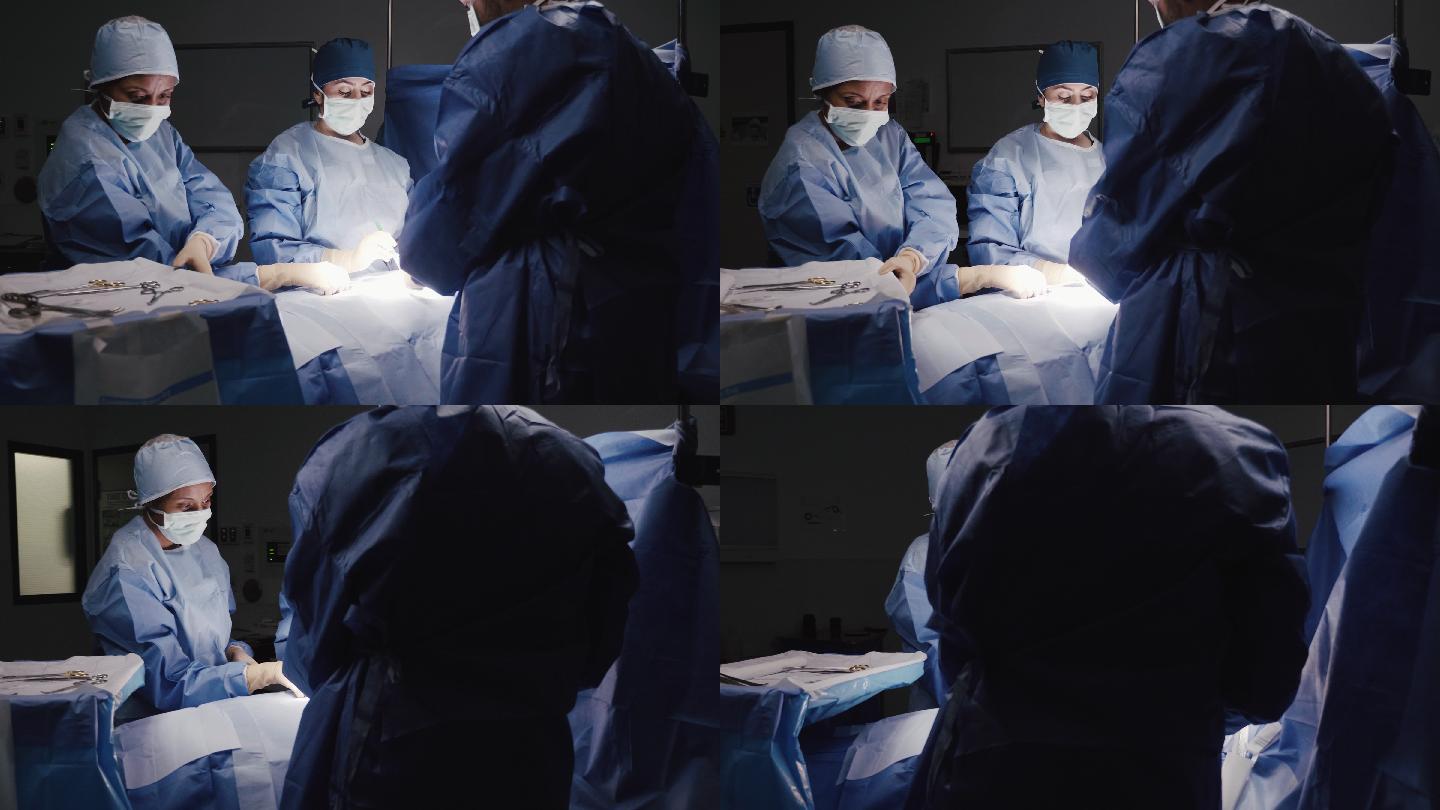 细心的女外科医生在手术中使用手术器械