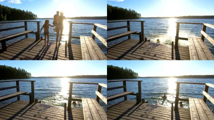 夫妇带着女儿在木码头上奔跑跳入湖中