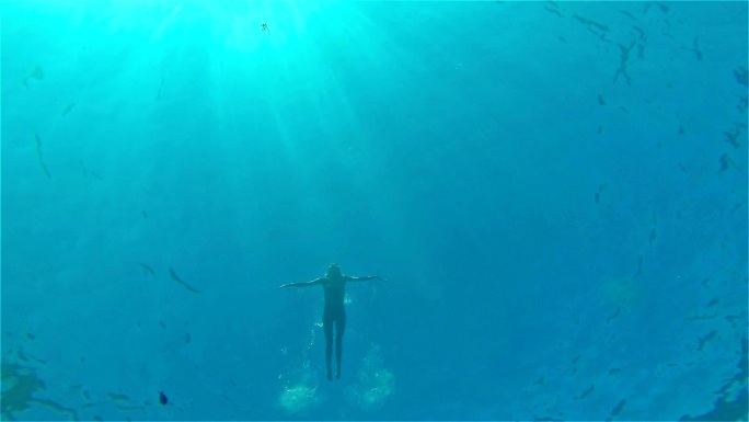 在海里游泳的女人仰视仰拍水下海底