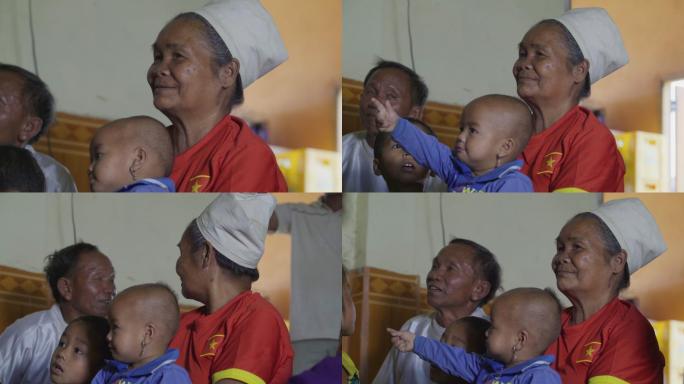 老挝农民一家人在家里看电视