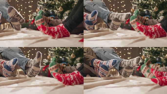 四个穿着圣诞袜的人坐在沙发和地板上
