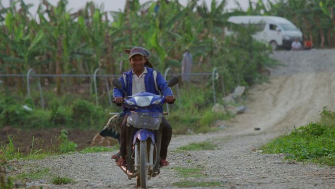 老挝香蕉种植园骑摩托车的农民