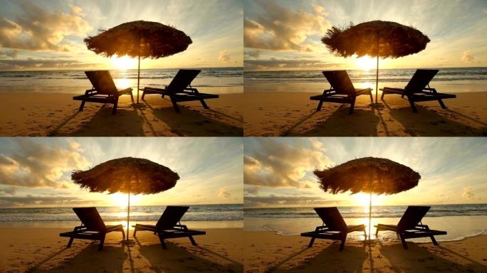 热带海滩日出，椅子和遮阳伞