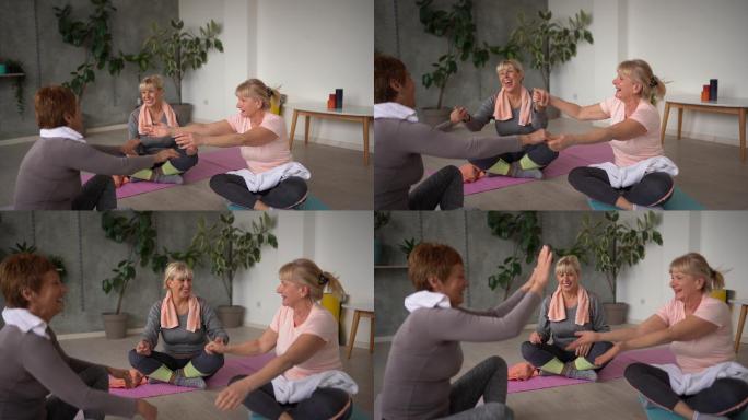 三位资深女性朋友在瑜伽工作室上完瑜伽课后放松