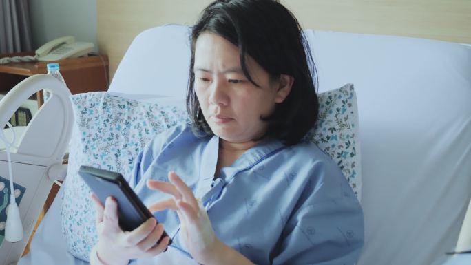 病床上使用手机的女病人
