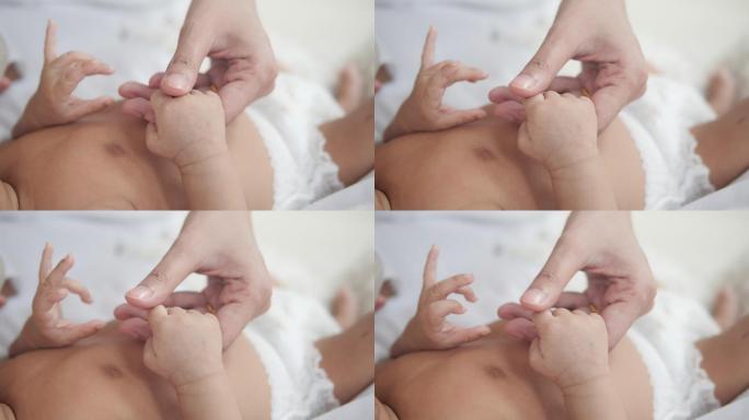 婴儿用爱牵着母亲的手指