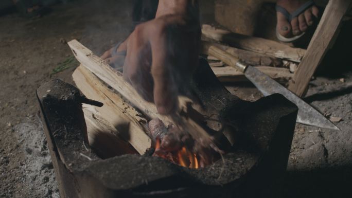 老挝农民劈劈柴烧火做饭