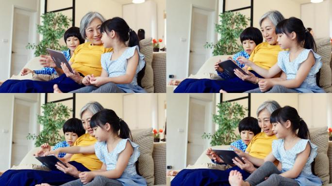 祖母和她的孙子们看着一台数码平板电脑