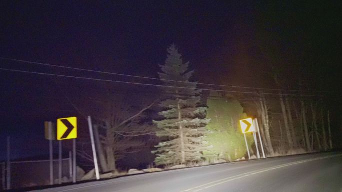 在乡村的公路上开车，在夜晚穿过山林。