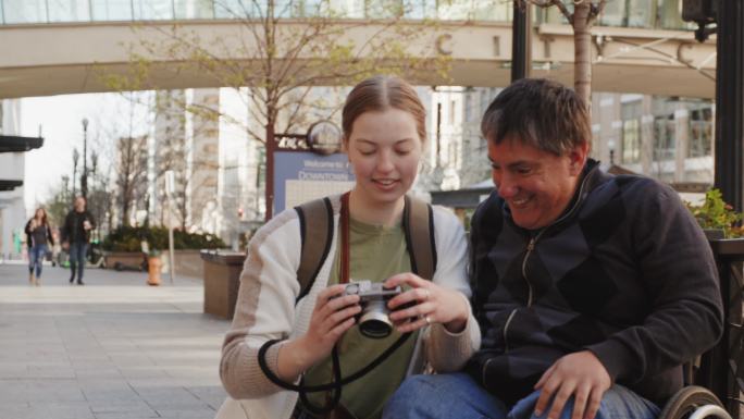 一位残疾人和一位朋友在市中心拍照