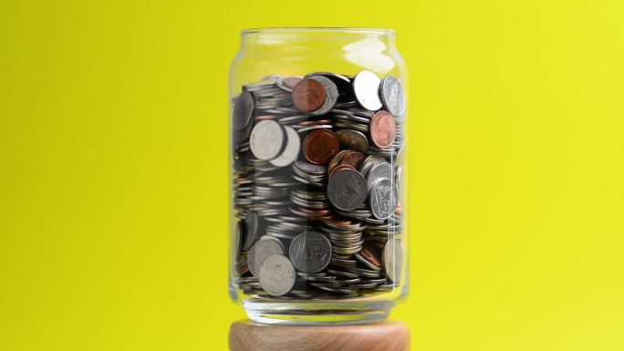 透明玻璃瓶中的硬币在旋转。