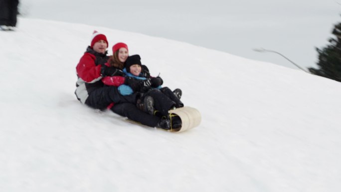 在雪地上滑雪橇雪乡爬犁玩雪一家人