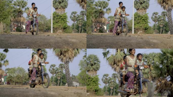 柬埔寨农村骑摩托车带孩子的女人