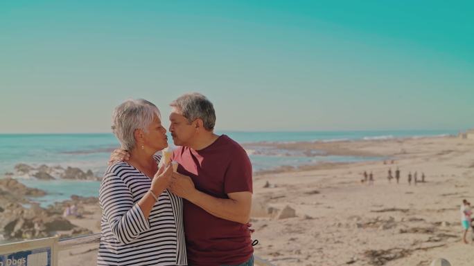 一对老年夫妇在海滩吃冰淇淋筒