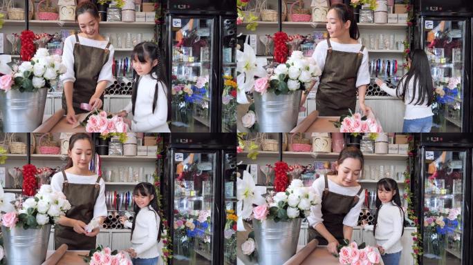 在打包鲜花的女人礼品店花艺制作母亲小女孩