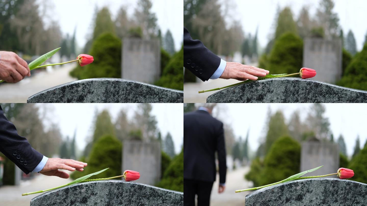 男人把花放在墓碑上