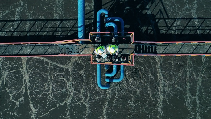 在废水处理设施工作的两名废水操作员的俯视图