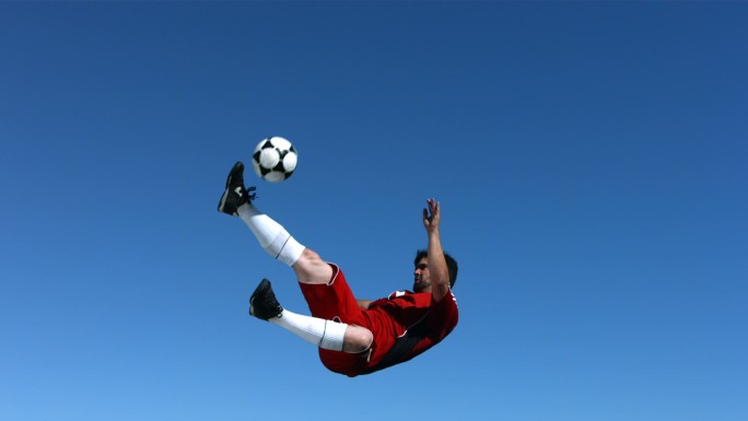 足球运动员在半空中慢动作踢球