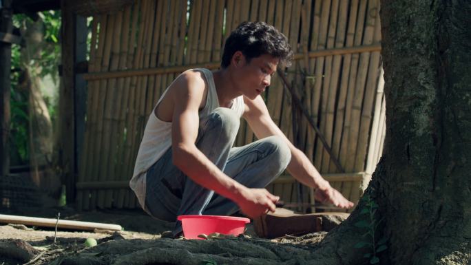 老挝乡村男人在石头上磨刀