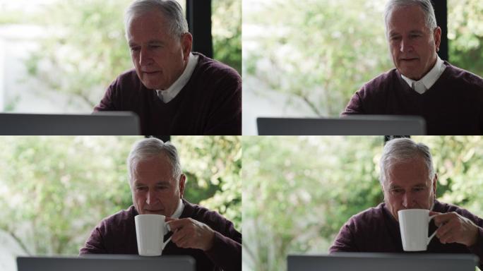 一位长者在家喝咖啡，使用笔记本电脑
