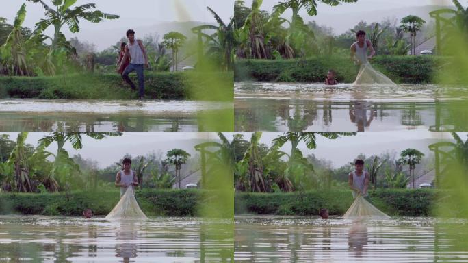 老挝乡村父子在池塘边抛渔网