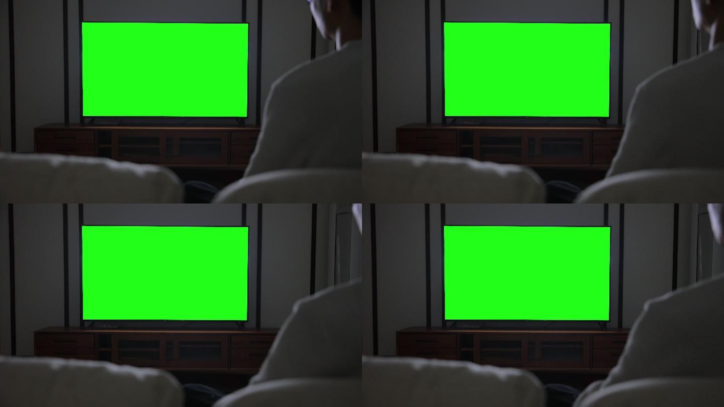 男子用绿色屏幕看电视
