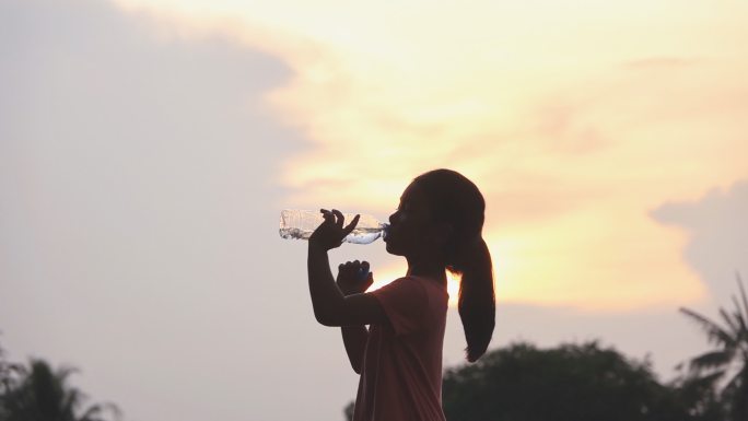 小女孩在公园喝水剪影逆光矿泉水纯净水