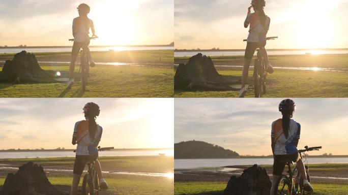 骑自行车的女子站在夕阳的阴影下
