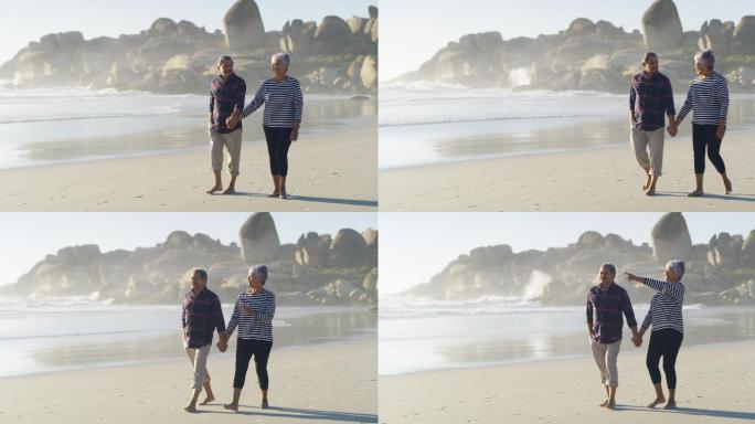 老年夫妇手牵着手沿着海滩散步