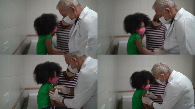 给一个小女孩病人注射疫苗的医生
